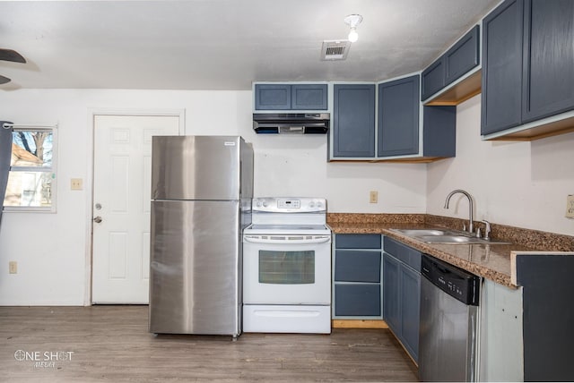 kitchen featuring blue cabinets, under cabinet range hood, stainless steel appliances, and a sink