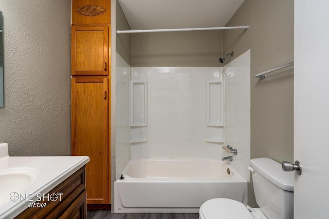 full bath with shower / washtub combination, a textured wall, vanity, and toilet