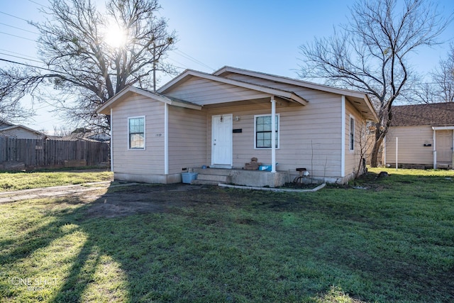 bungalow-style house with a front yard and fence