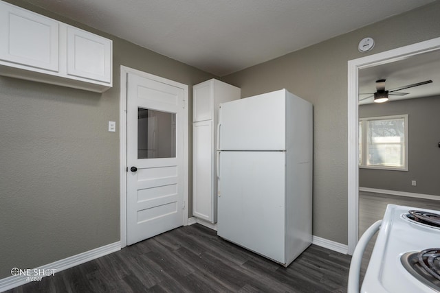 kitchen featuring white appliances, baseboards, dark wood-style floors, and white cabinetry