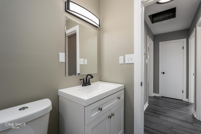 bathroom featuring a textured wall, vanity, toilet, and wood finished floors