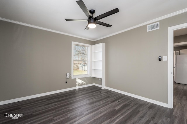 unfurnished room featuring dark wood-style floors, baseboards, visible vents, and crown molding