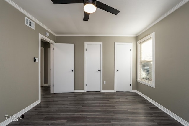 unfurnished bedroom featuring ornamental molding, dark wood-type flooring, visible vents, and baseboards