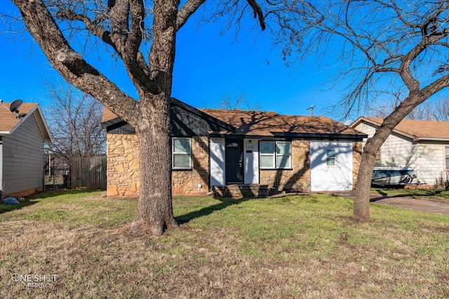 ranch-style house featuring a garage, stone siding, fence, and a front lawn