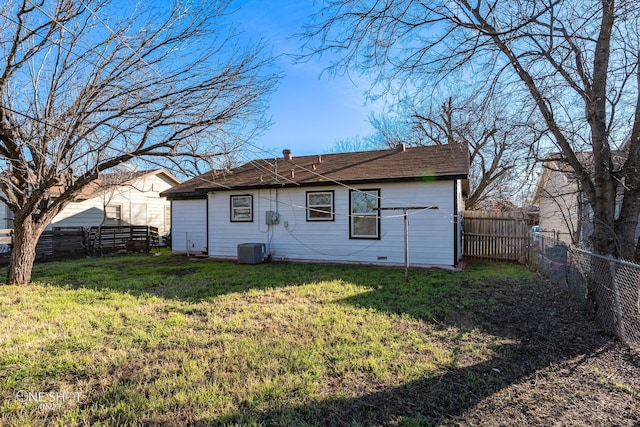 rear view of house with a lawn, cooling unit, and a fenced backyard