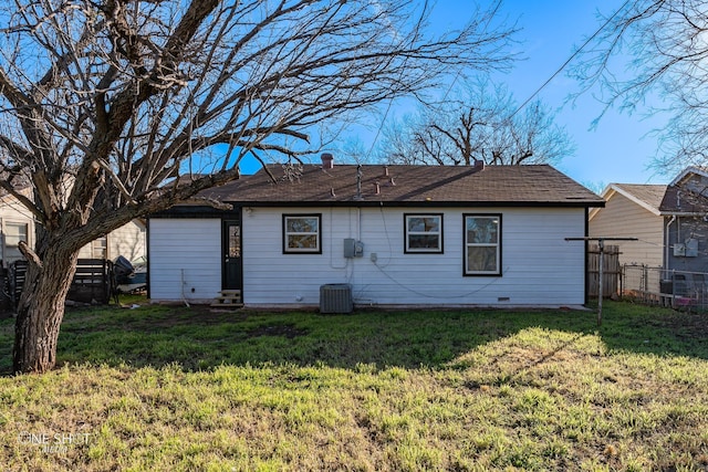 rear view of property featuring entry steps, a yard, and fence