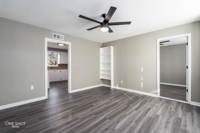 unfurnished bedroom featuring baseboards, visible vents, ceiling fan, dark wood-type flooring, and a closet