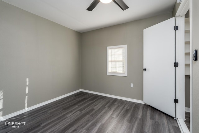 empty room featuring dark wood-type flooring, baseboards, and a ceiling fan