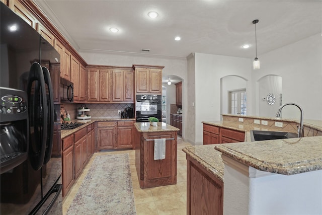 kitchen featuring arched walkways, a spacious island, a sink, black appliances, and tasteful backsplash