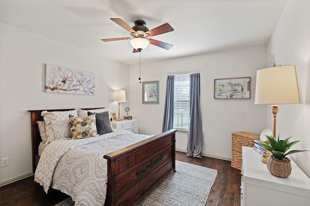 bedroom featuring dark wood-style flooring, a ceiling fan, and baseboards