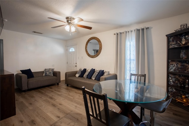 dining area featuring a ceiling fan, visible vents, and wood finished floors