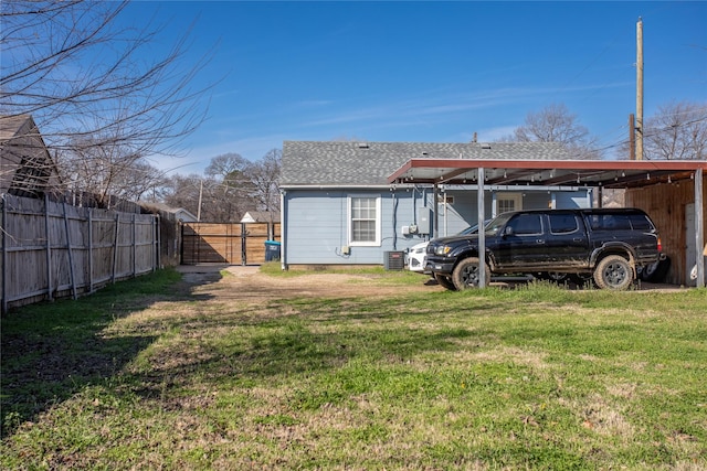 view of yard featuring a carport, fence, and a gate