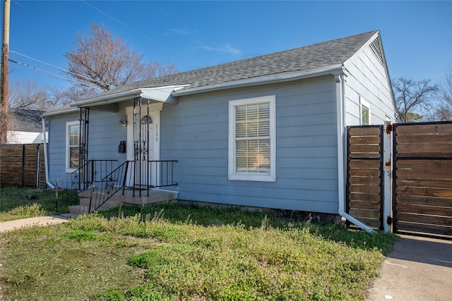 bungalow with roof with shingles and fence