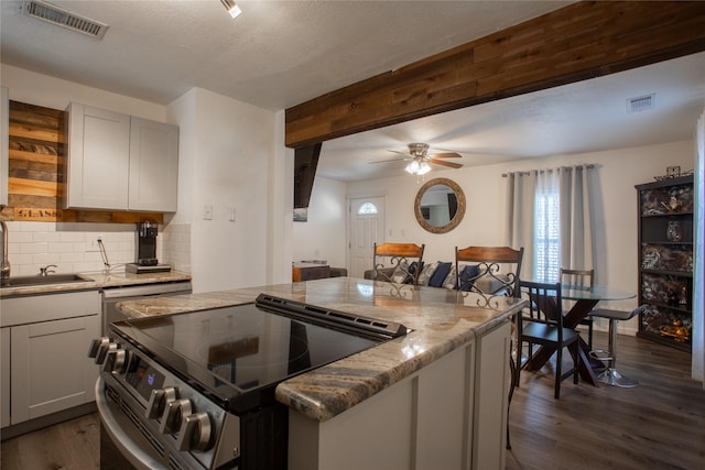 kitchen with stainless steel range with electric cooktop, a sink, visible vents, and light stone countertops