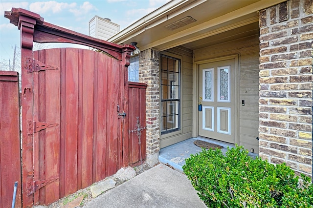 entrance to property with a chimney and brick siding