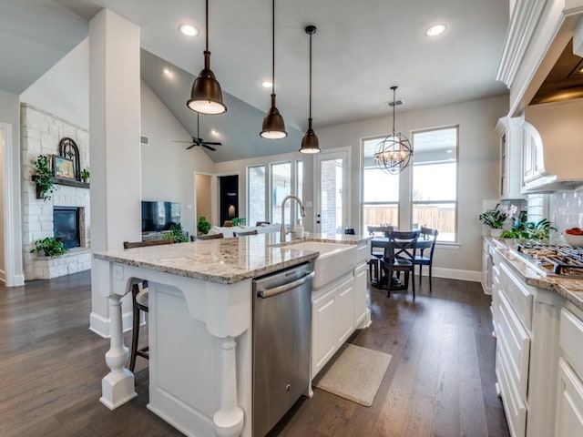 kitchen with dark wood-style flooring, a sink, baseboards, stainless steel appliances, and white cabinetry