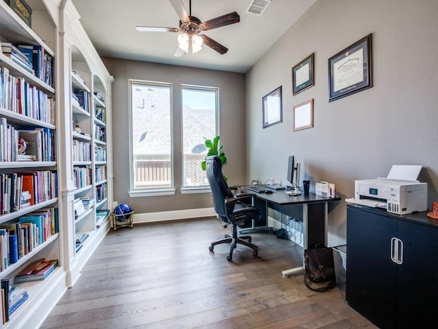 office area featuring visible vents, a ceiling fan, baseboards, and wood finished floors