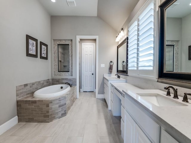 bathroom with a bath, visible vents, a sink, and lofted ceiling