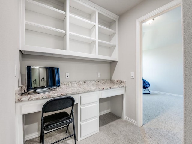 office with baseboards, light colored carpet, and built in study area