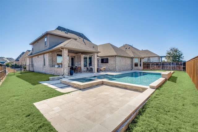 view of swimming pool featuring a lawn, a fenced backyard, a patio area, and a pool with connected hot tub