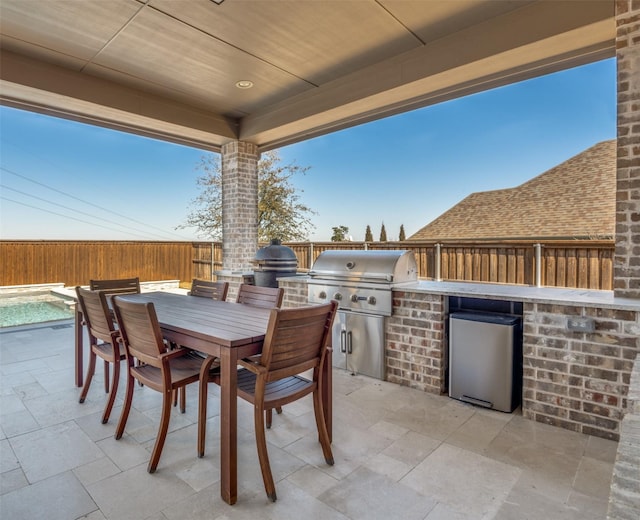 view of patio with grilling area, a fenced in pool, a fenced backyard, an outdoor kitchen, and outdoor dining space