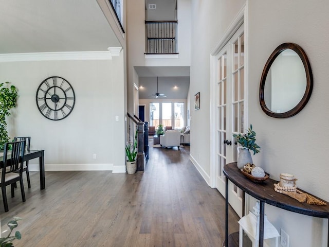 entrance foyer featuring crown molding, baseboards, stairway, french doors, and wood finished floors