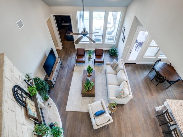 living room with visible vents, baseboards, ceiling fan, and wood finished floors
