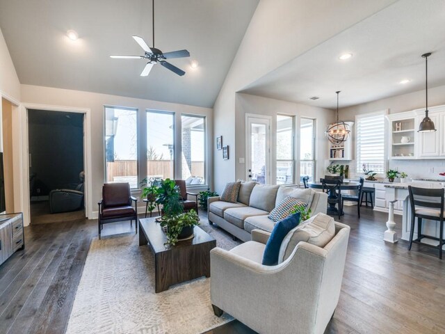 living area featuring recessed lighting, ceiling fan with notable chandelier, wood finished floors, and high vaulted ceiling