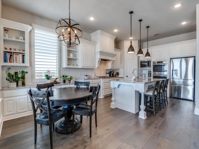 kitchen featuring an inviting chandelier, appliances with stainless steel finishes, white cabinets, and tasteful backsplash