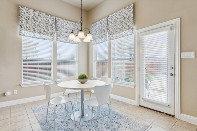 dining room with a chandelier, tile patterned flooring, and baseboards