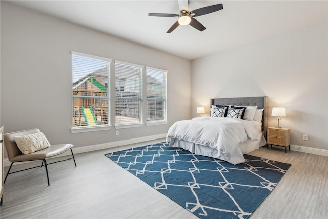 bedroom with ceiling fan, baseboards, and wood finished floors