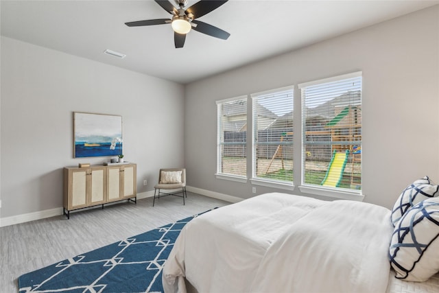 bedroom with ceiling fan, wood finished floors, visible vents, and baseboards