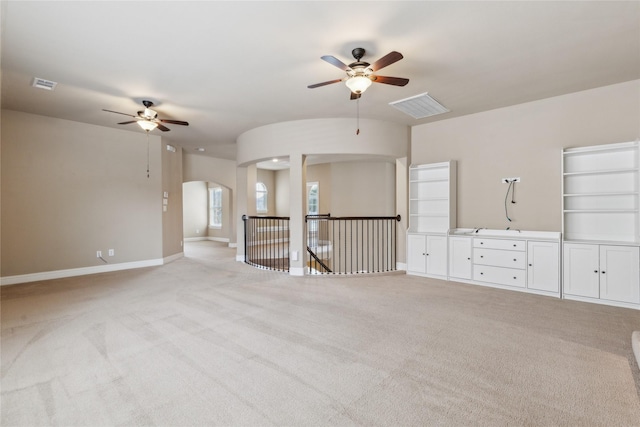 unfurnished room with visible vents, ceiling fan, light carpet, and baseboards