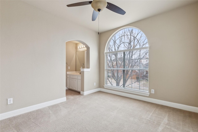 unfurnished room with baseboards, ceiling fan, a wealth of natural light, and light colored carpet