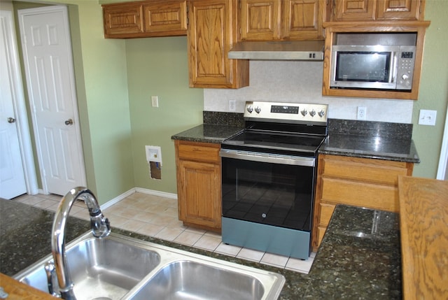 kitchen with a sink, stainless steel appliances, exhaust hood, and brown cabinets