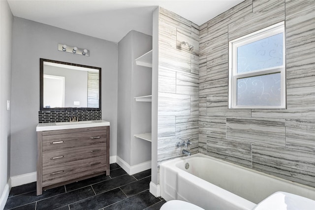 bathroom featuring baseboards, bathing tub / shower combination, toilet, tile patterned flooring, and vanity