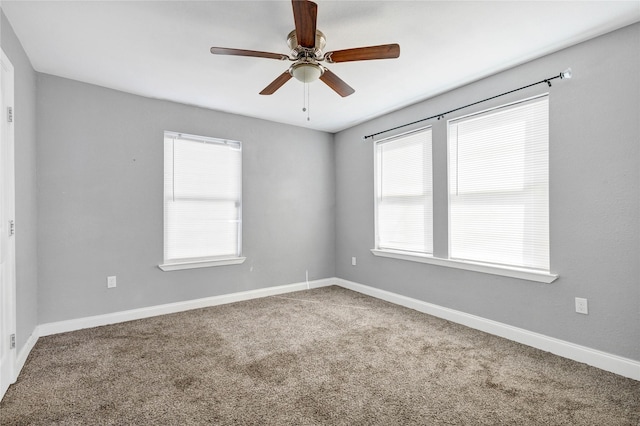 empty room with ceiling fan, carpet, and baseboards