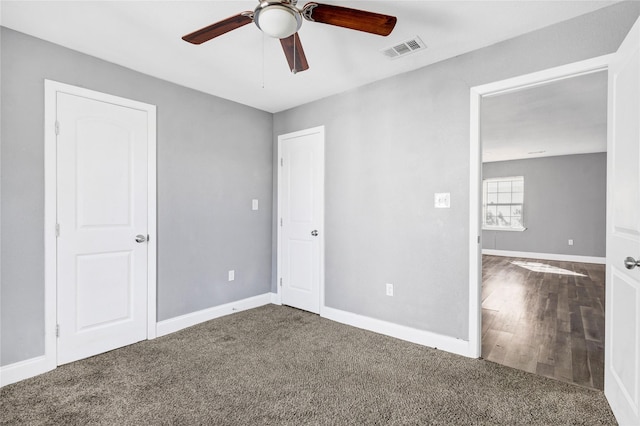 unfurnished bedroom with a ceiling fan, carpet, visible vents, and baseboards