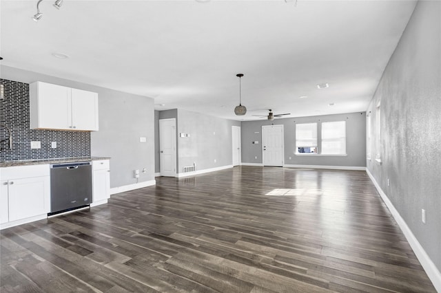 unfurnished living room with dark wood-type flooring, visible vents, ceiling fan, and baseboards