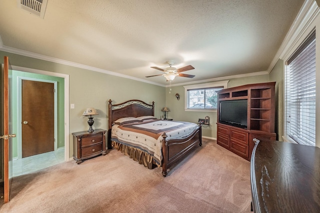 bedroom featuring ornamental molding, light colored carpet, visible vents, and a textured ceiling