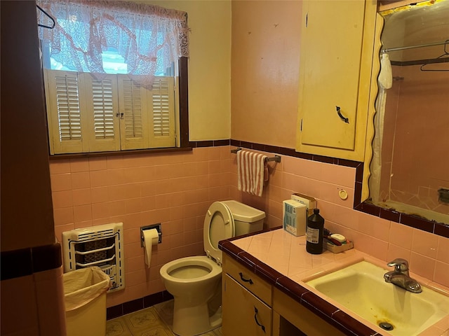 bathroom featuring heating unit, a shower with curtain, toilet, and vanity