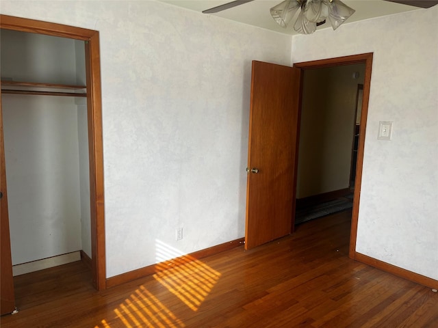 unfurnished bedroom featuring a closet, baseboards, and hardwood / wood-style floors