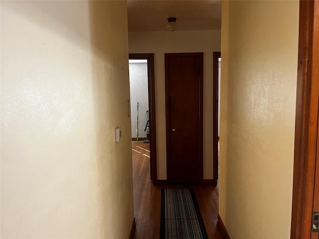 hallway featuring a textured wall and wood finished floors