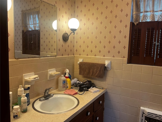 bathroom featuring wainscoting, heating unit, vanity, and wallpapered walls