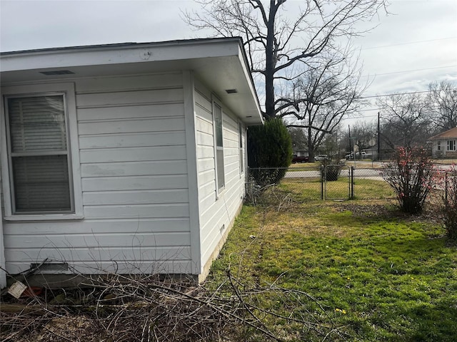 view of home's exterior featuring a lawn and fence