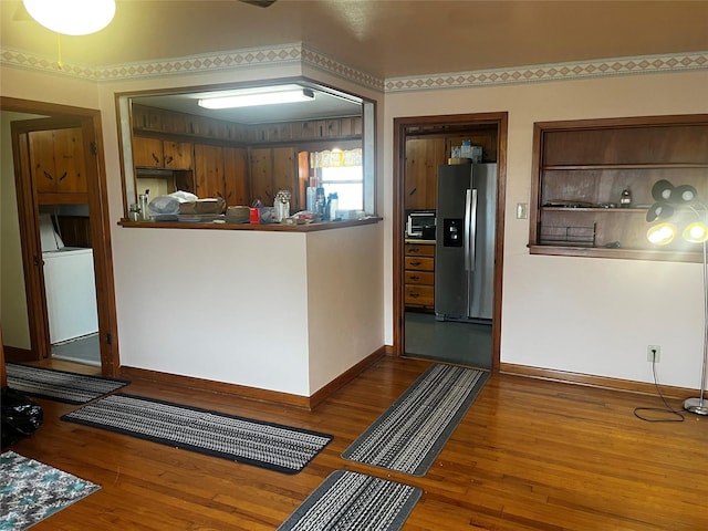 kitchen with baseboards, stainless steel fridge, washer / clothes dryer, and wood finished floors