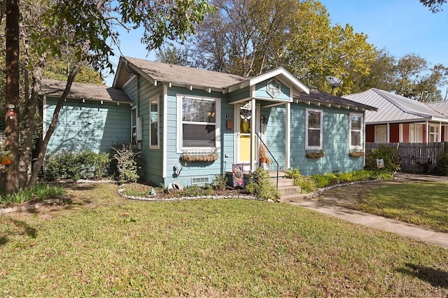 view of front of house with crawl space, fence, and a front lawn