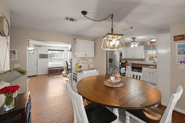 dining space featuring baseboards, light wood-style flooring, visible vents, and a ceiling fan