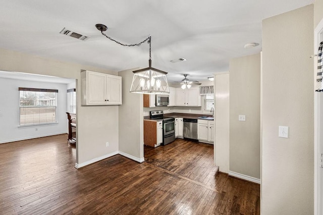 kitchen with visible vents, white cabinets, appliances with stainless steel finishes, dark wood-type flooring, and decorative light fixtures