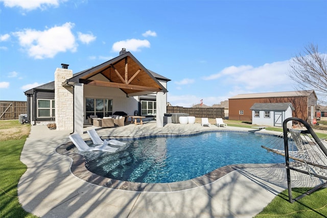 view of pool featuring a fenced in pool, a patio area, a fenced backyard, and an outdoor structure